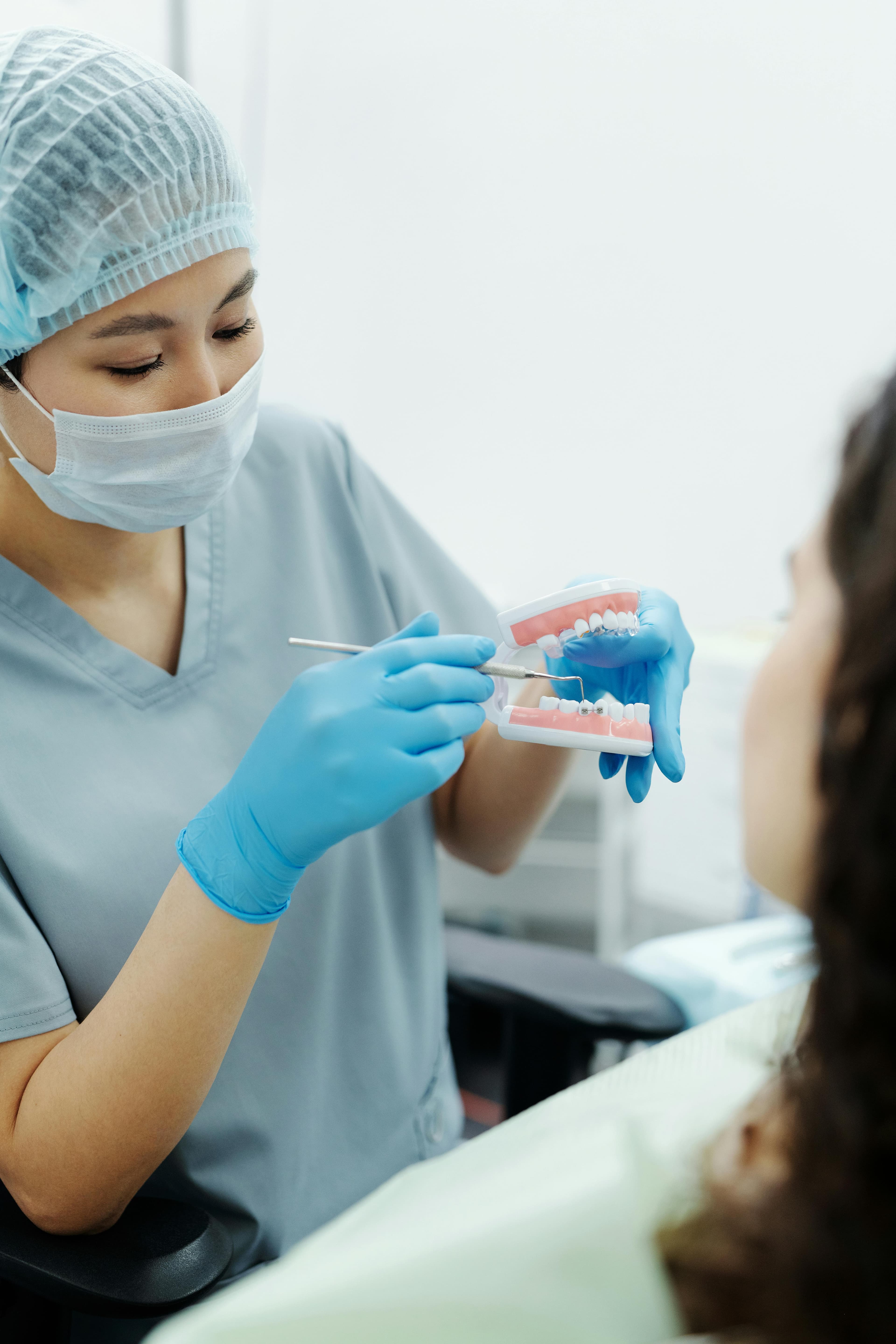 Woman in Blue Scrub Shirt Holding Dental Tool